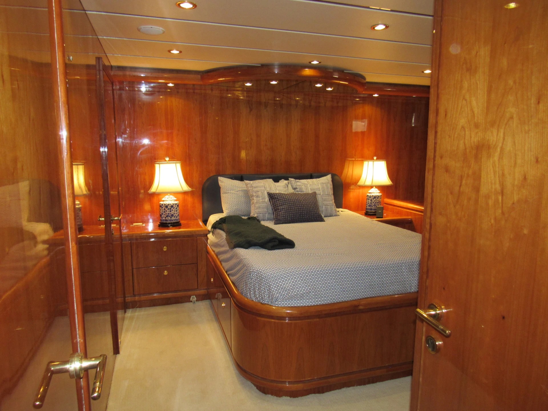 Sanctuary charter yacht stateroom with warm wood paneling and ambient lighting